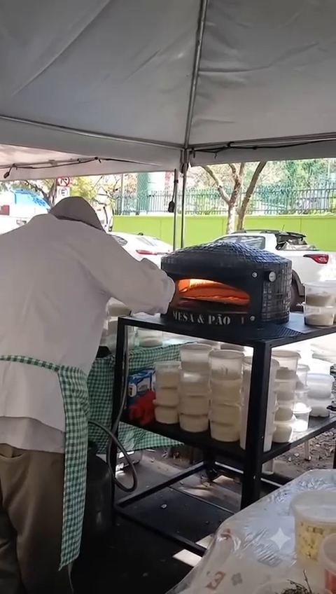 Chef Rodrigo colocando a pizza no forno Mesa & Pão